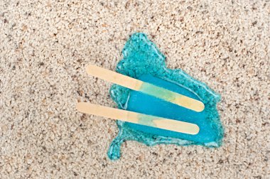 Melting popsicle on carpet. clipart