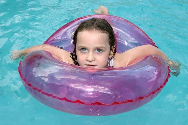 Little girl swimming with safety ring — Stock Photo, Image