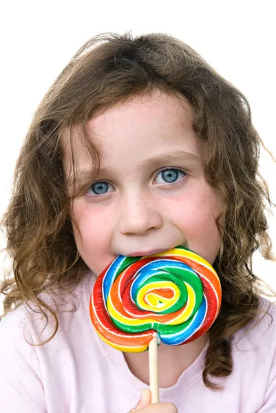 Маленькая девочка и колёсик конфеты сосут — стоковое фото