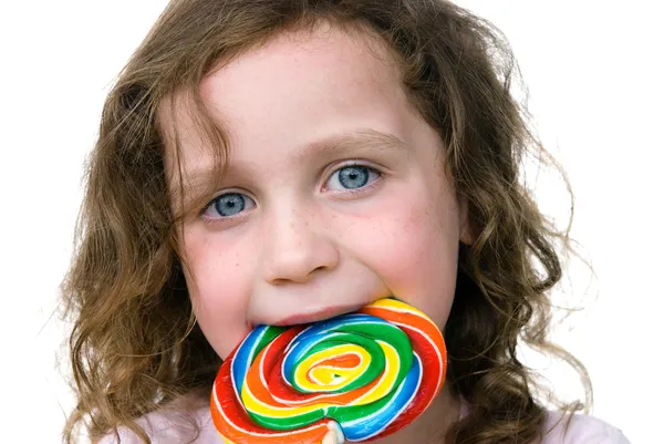 Маленькая девочка улыбается своим конфетным колесом сосунка — стоковое фото
