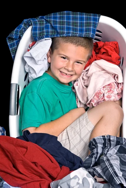 Хлопчик в кошику одягу — стокове фото