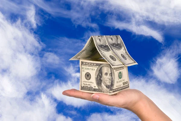 Geld huis gehouden tegen de hemel — Stockfoto
