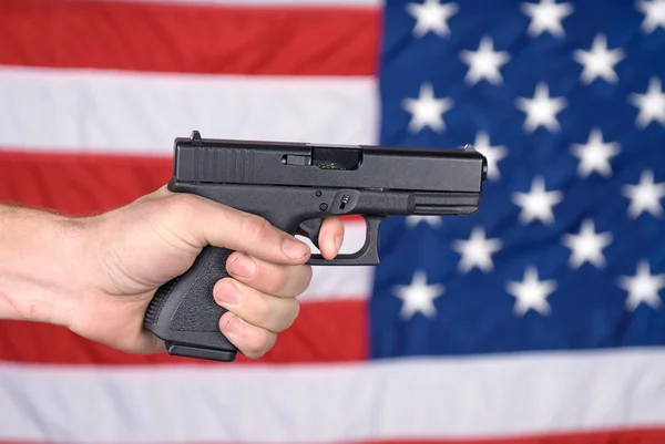 Amerikaanse vlag en hand gehouden pistool — Stockfoto