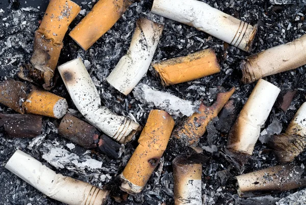 Verbrande sigarettenpeuken en as — Stockfoto