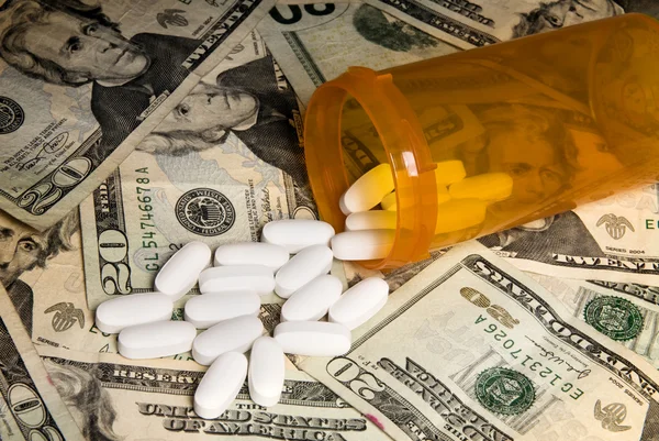 Spilled pills on money — Stock Photo, Image