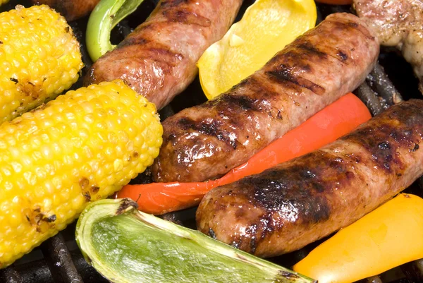 Bratwurst and corn cob on barbecue — Stock Photo, Image
