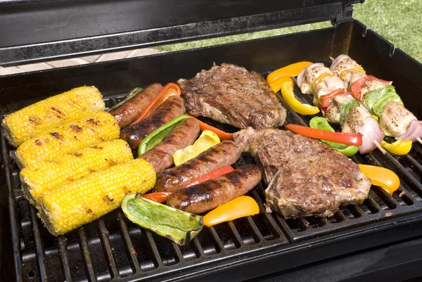 Barbecued steaks, brats, corn and chicken — Stock Photo, Image