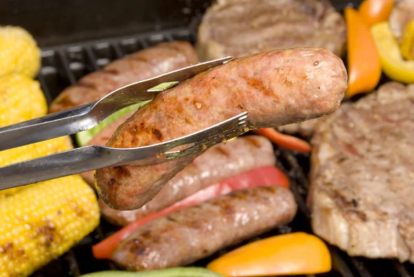 Barbecued bratwurst and steaks — Stock Photo, Image