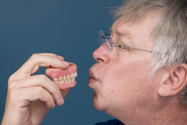 Man kissing dentures — Stock Photo, Image