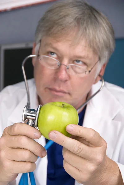 Le médecin examine une pomme — Photo