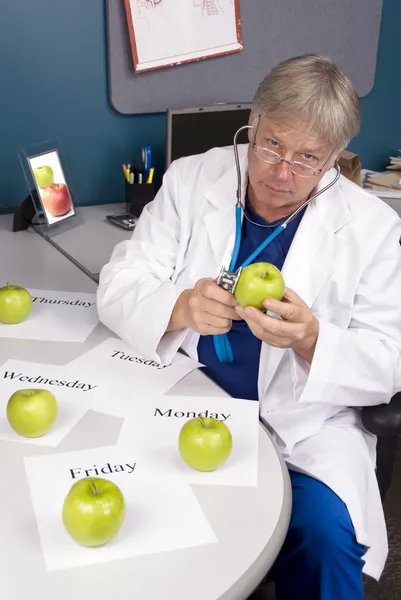 Lekarz bada jabłko — Zdjęcie stockowe
