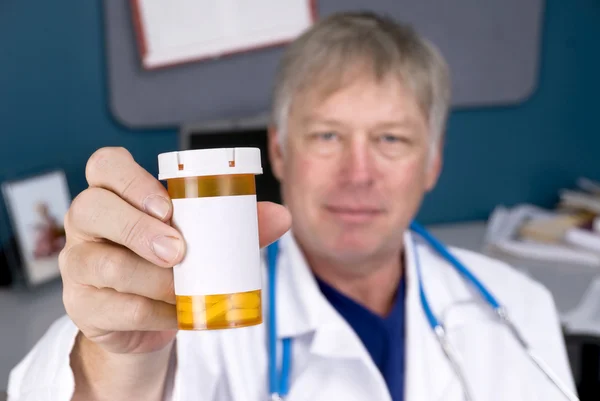 Доктор держит бутылку с таблетками — стоковое фото