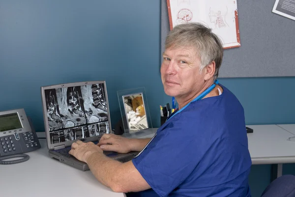 Doctor reviewing MRI on laptop — Stock Photo, Image