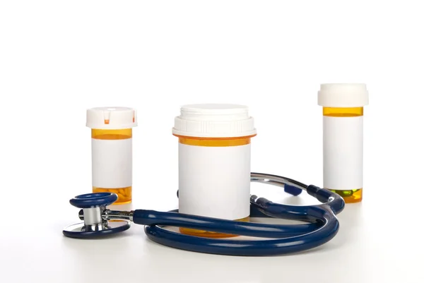 Pill bottles with blank labels and stethoscope — Stock Photo, Image