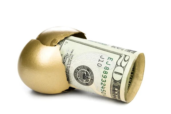 Вылупившееся золотое яйцо с деньгами — стоковое фото