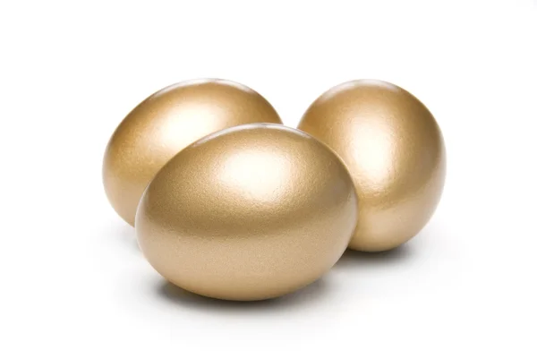 Золотые яйца на белом фоне — стоковое фото