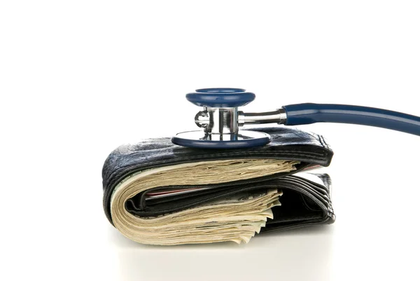 Tapet med kontanter som blir undersøkt med stetoskop – stockfoto