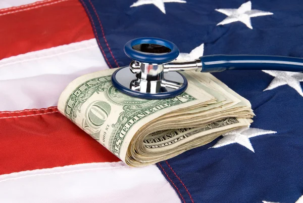 Bandeira americana com pilha de dinheiro e estetoscópio — Fotografia de Stock