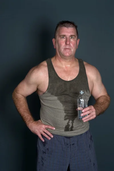 Muscular man with bottled water — Stock Photo, Image