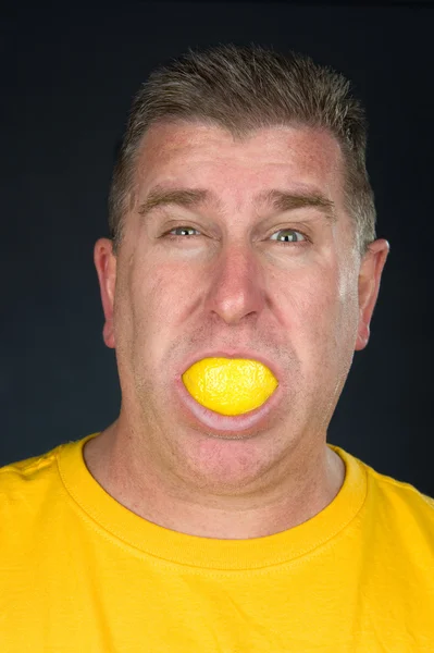 Человек, сосущий лимон — стоковое фото