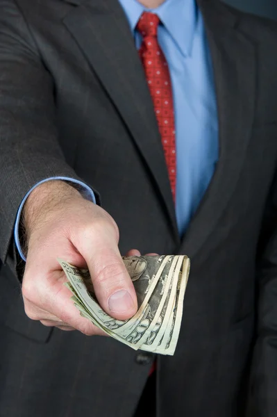 Zakenman contant geld overhandigen — Stockfoto