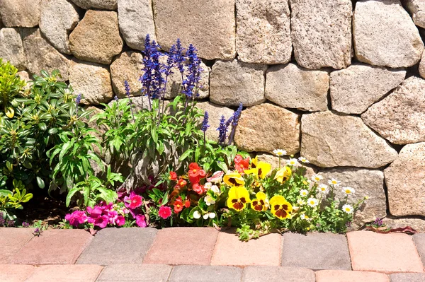 Flower garden along stone wall