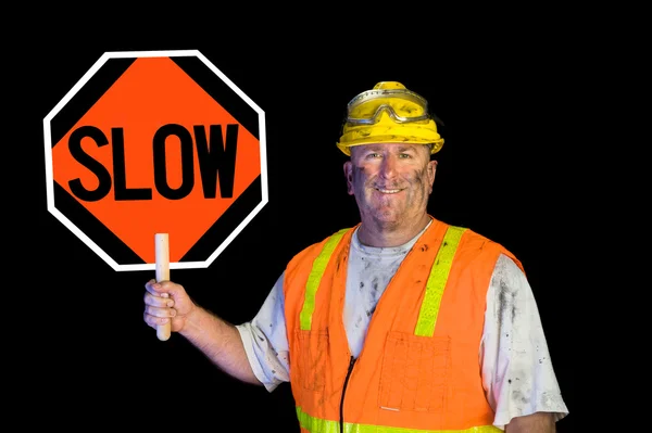 Sucio trabajador de la construcción sosteniendo lento signo — Foto de Stock