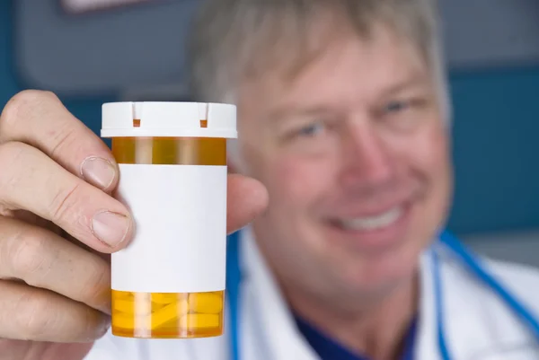 Врач-фармацевт и бутылка с таблетками — стоковое фото