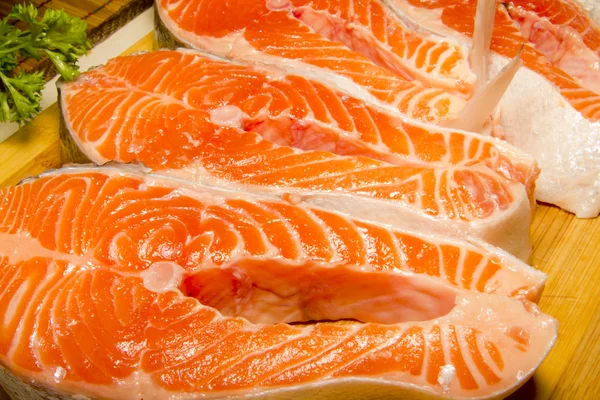 Bifes de salmão em uma tábua de cortar — Fotografia de Stock