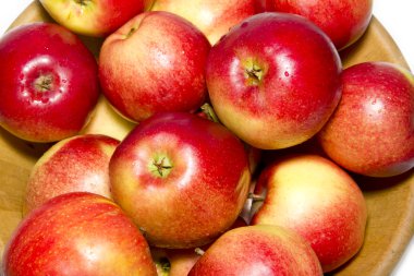 Red apples in a wooden plate