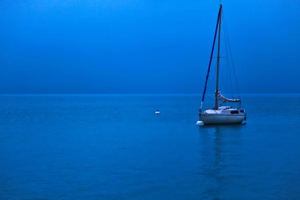 Рассвет и парусная лодка — стоковое фото