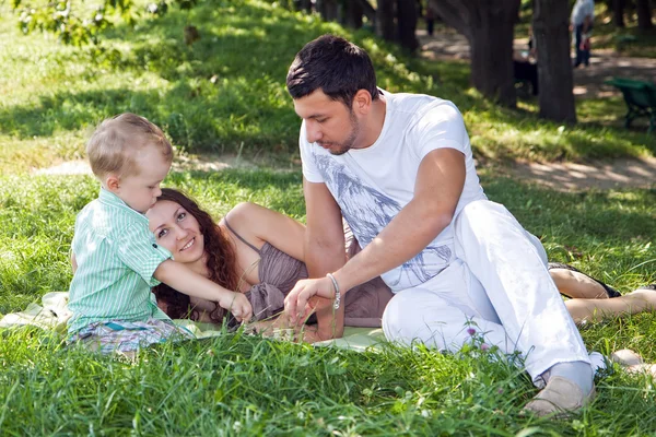 Jonge gezin ontspannen in park — Stockfoto