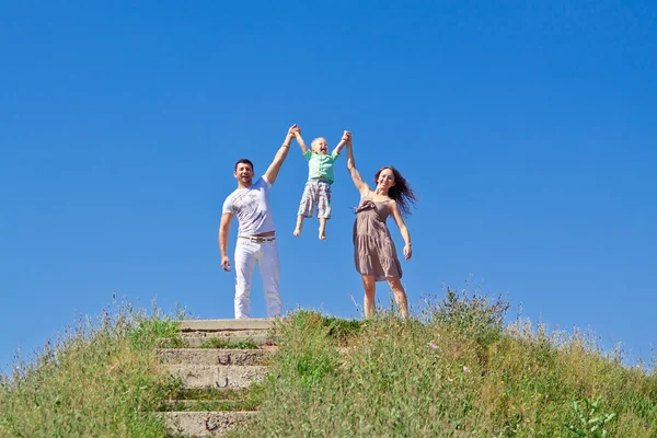 Mavi gökyüzü üzerinde mutlu bir aile — Stok fotoğraf