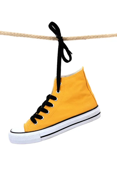 Stijlvolle gele sneaker met zwarte schoenriem — Stockfoto