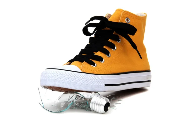 Stylish yellow sneaker with brocken bulb — Stock Photo, Image