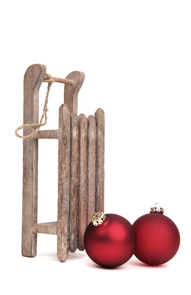 Old wooden sledge with two christmas baubles — Stock Photo, Image