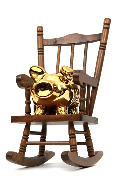 Stare drewniane krzesło bujane i złota skarbonka na biały — Zdjęcie stockowe