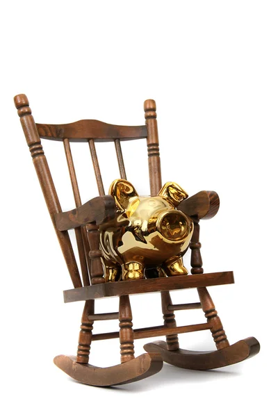 Старое деревянное кресло-качалка и золотая копилка на белом — стоковое фото
