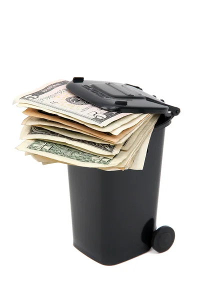 Batch of bank notes in black rubbish bin on white — Stock Photo, Image
