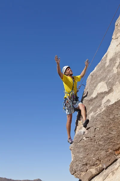 Mannelijke rock klimmer klampt zich vast aan een klif. — Stockfoto