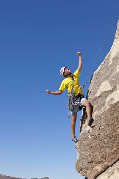Manliga bergsklättrare klänger på en klippa. — Stockfoto