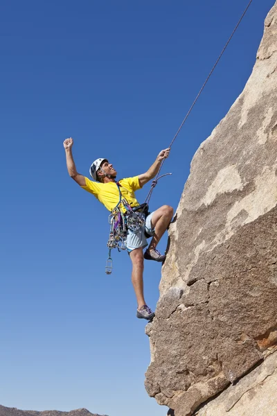Manliga bergsklättrare klänger på en klippa. — Stockfoto