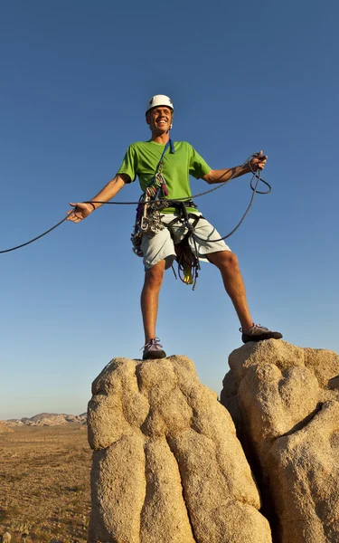 Mannelijke rock klimmer klampt zich vast aan een klif. — Stockfoto