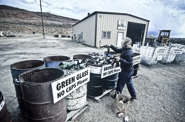 Γυναίκα ανακυκλώνει γυάλινες φιάλες. — Φωτογραφία Αρχείου