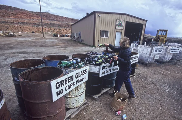 Žena recykluje skleněných lahví. — Stock fotografie