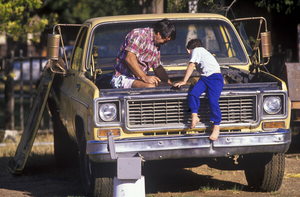 Father and son fixing truck.