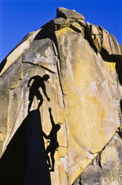 Rock climbing team reaching the summit. clipart