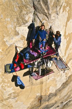 Rock climbing team bivouaced on a bigwall. clipart