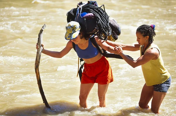 Equipe de escalada atravessando um rio . — Fotografia de Stock