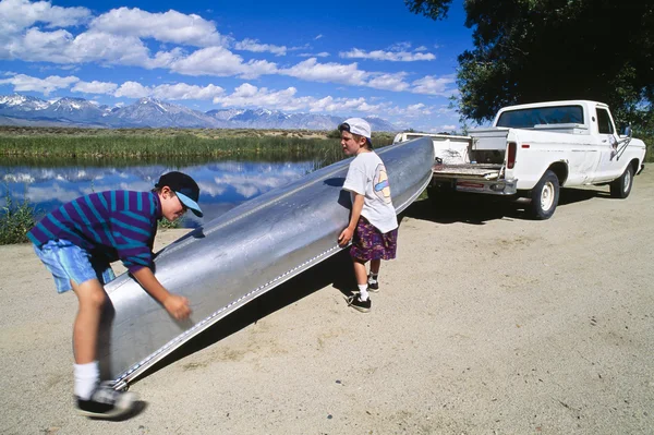 Meninos carregando canoa em caminhão . — Fotografia de Stock